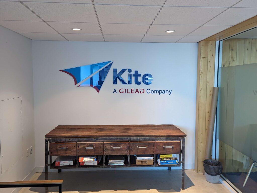 A modern corporate office space at Kite, a Gilead Company on Market Street, Philadelphia, featuring a newly installed wall logo and a sleek custom credenza. The design incorporates contemporary branding elements, clean lines, and high-quality materials, enhancing the professional and innovative atmosphere of the workspace.